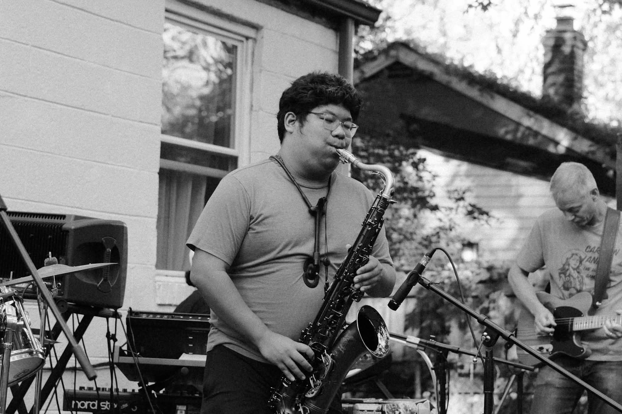 Playing sax in greyscale, outdoors